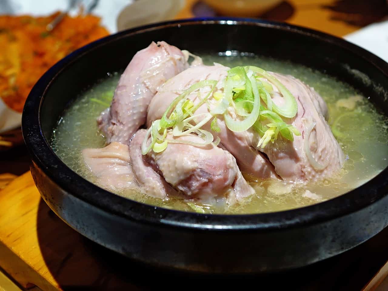 a bowl of bland soup with chicken and onions