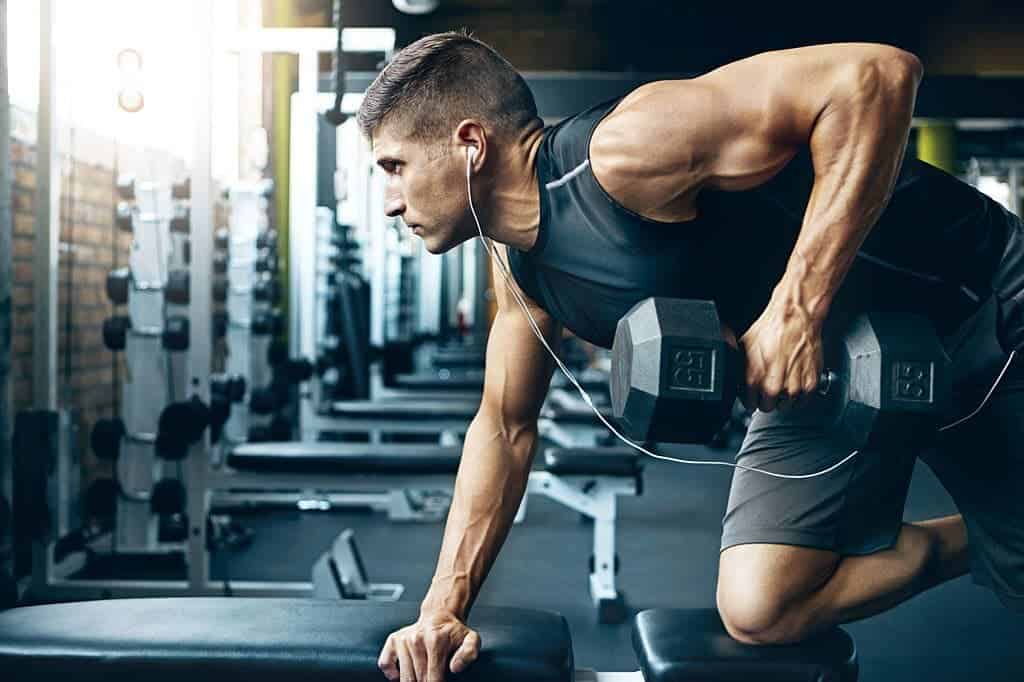Man exercising with dumbbell on workout bench