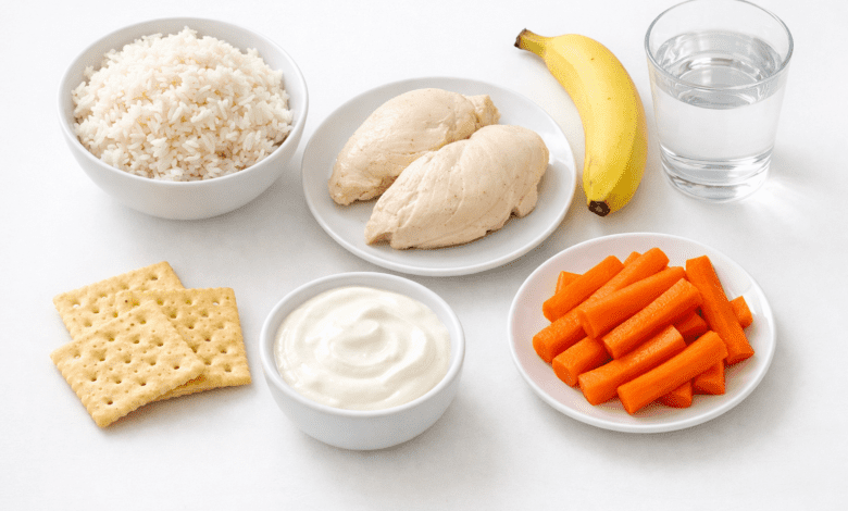 A clean, bright flat-lay photograph of bland diet foods arranged on a white surface: plain white rice, steamed chicken